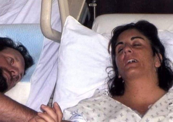 The husband stands by while his wife is taken off life support, but she turns around and yells, “Get me out of here!”